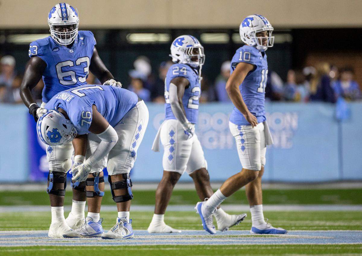 North Carolina’s Ed Montilus (63) consoles teammate William Barnes (76) following an interception by Virginia’s James Jackson (7) with 26 seconds to play in the game, securing a 31-27 Virginia victory on Saturday, October 21, 2023 at Kenan Stadium in Chapel Hill, N.C.