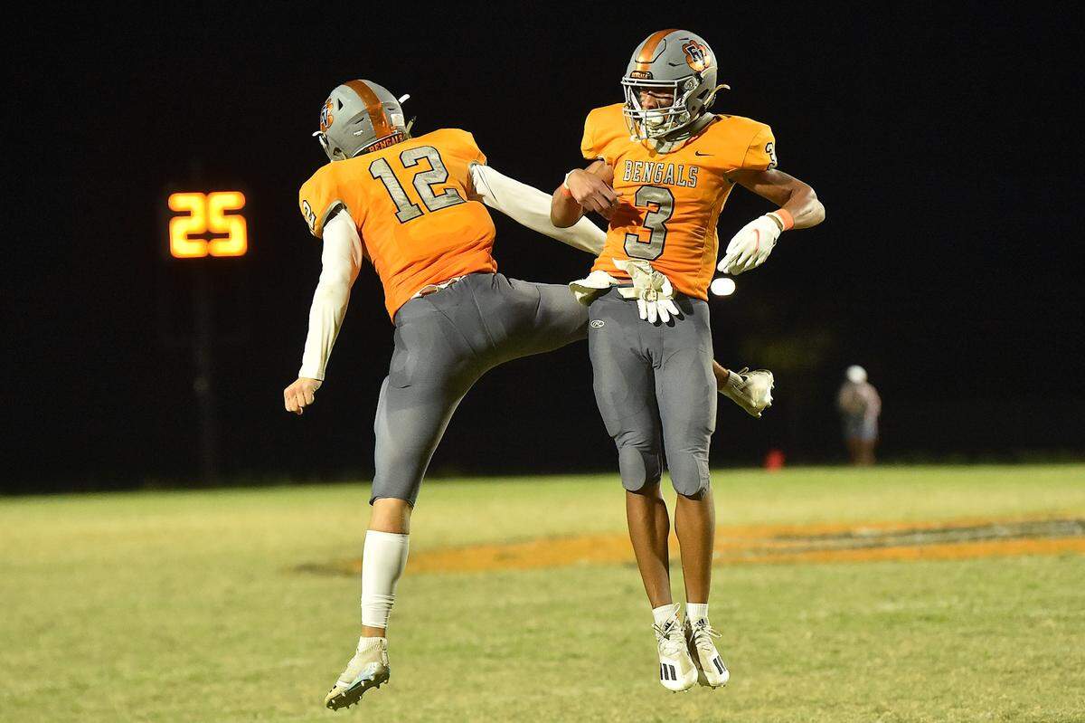 Fuquay-Varina’s Malcolm Ziglar (3) celebrates with Dylan Smith (12) after the game winning touchdown late in the fourth quarter. The Fuquay-Varina Bengals and the Holly Springs Golden Hawks met in a non-conference football game in Fuquay-Varina, NC on September 3, 2021.