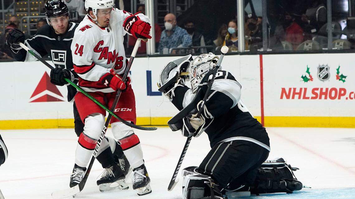 Los Angeles Kings goaltender Cal Petersen, right, stop a shot in front of Carolina Hurricanes center Seth Jarvis (24) during the first period of hockey game Saturday, Nov. 20, 2021, in Los Angeles. (AP Photo/Marcio Jose Sanchez)