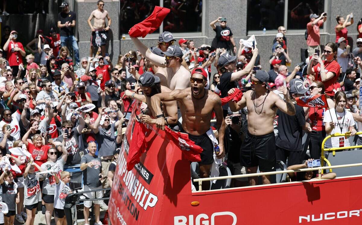 Canes players including Carolina's K'andre Miller, center, celebrate during a parade and rally for the Carolina Hurricanes in downtown Raleigh Saturday, June 20, 2026.