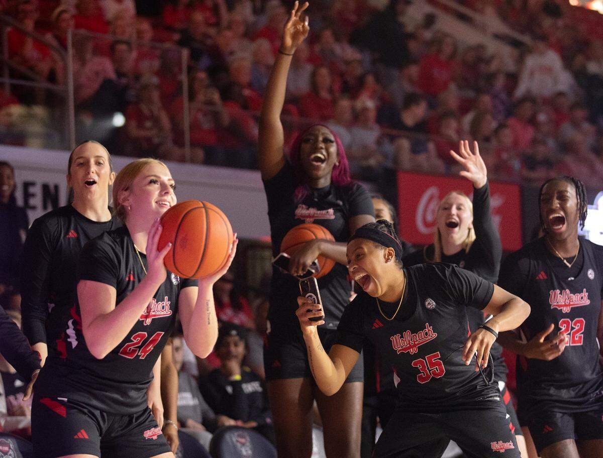 Teammates encourage Laci Steele during a three-point contest at the Primetime with the Pack preseason event on Friday, Oct. 25, 2024, at Reynolds Coliseum in Raleigh, N.C.