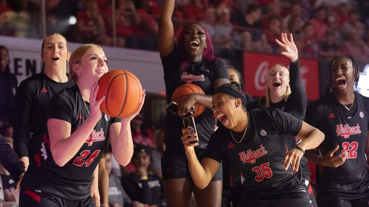 Teammates encourage Laci Steele during a three-point contest at the Primetime with the Pack preseason event on Friday, Oct. 25, 2024, at Reynolds Coliseum in Raleigh, N.C.