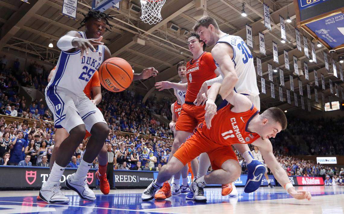 Duke’s Mark Mitchell (25) goes after the ball as Kyle Filipowski (30) and Clemson’s Joseph Girard III (11) get tangled up during the second half of Duke’s 72-71 victory over Clemson at Cameron Indoor Stadium in Durham, N.C., Saturday, Jan. 27, 2024.