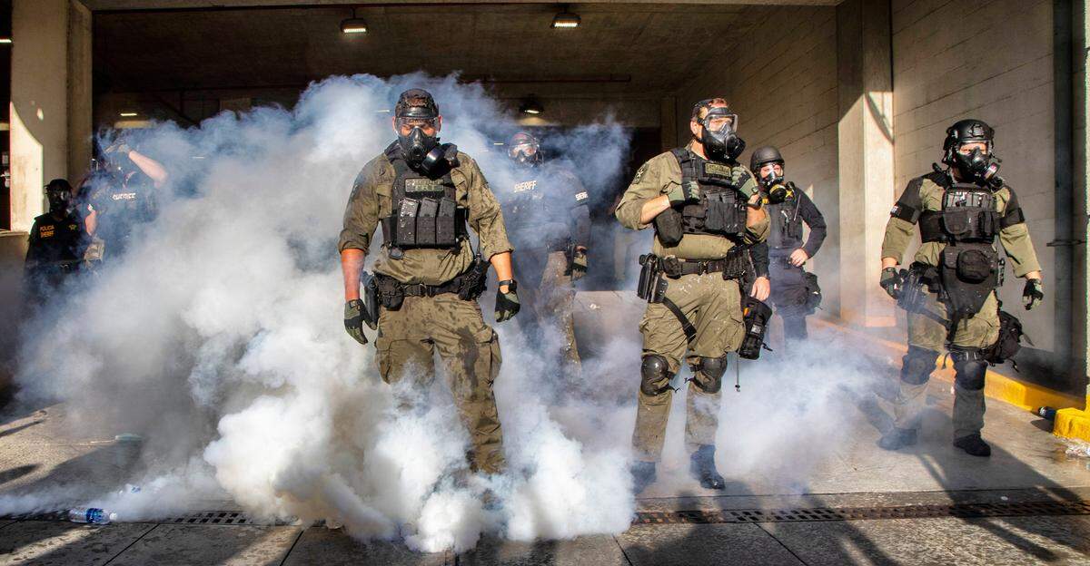 Police in riot gear deploy tear gas and pepper spray against protesters inside the Wake County Public Safety Center parking deck in downtown Raleigh Saturday, May 30, 2020.