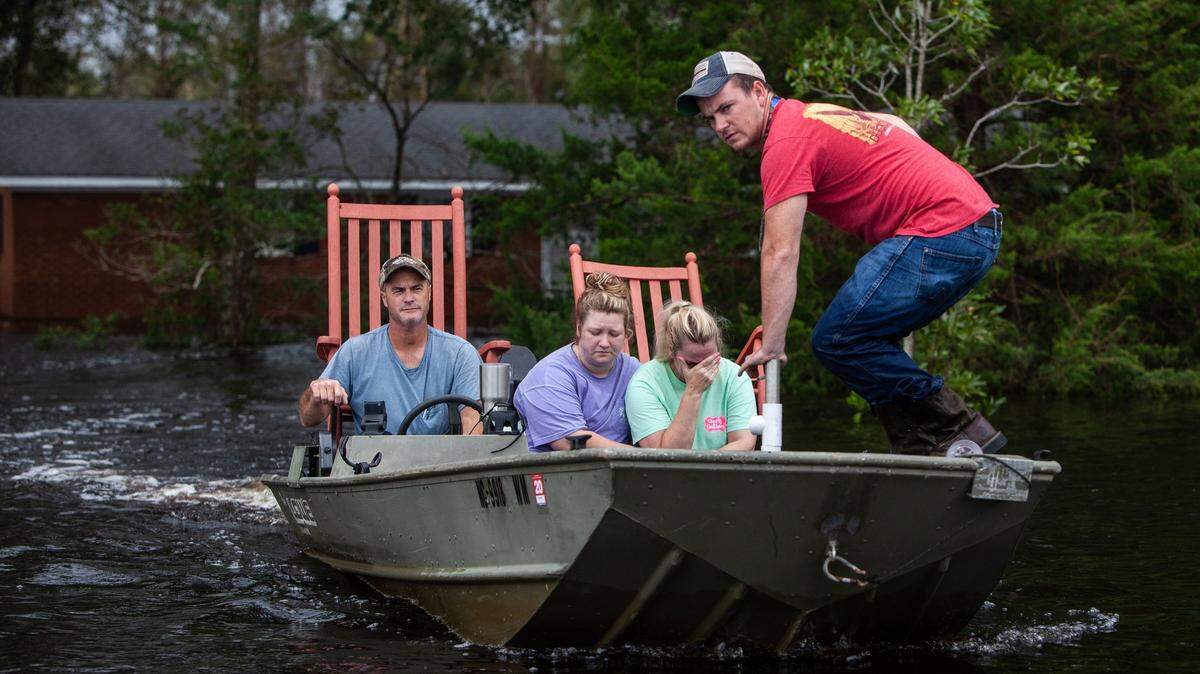 From left, Mike Haddock, 48, Katlyn Humphrey, 19, Michelle Haddock, 45, and Justin Humphrey, 24, remove possessions from the Haddock’s flooded home using a jon boat Monday, Sept. 17, 2018 in Trenton, NC following Hurricane Florence. Heavy floods are overwhelming treatment plants in small towns.