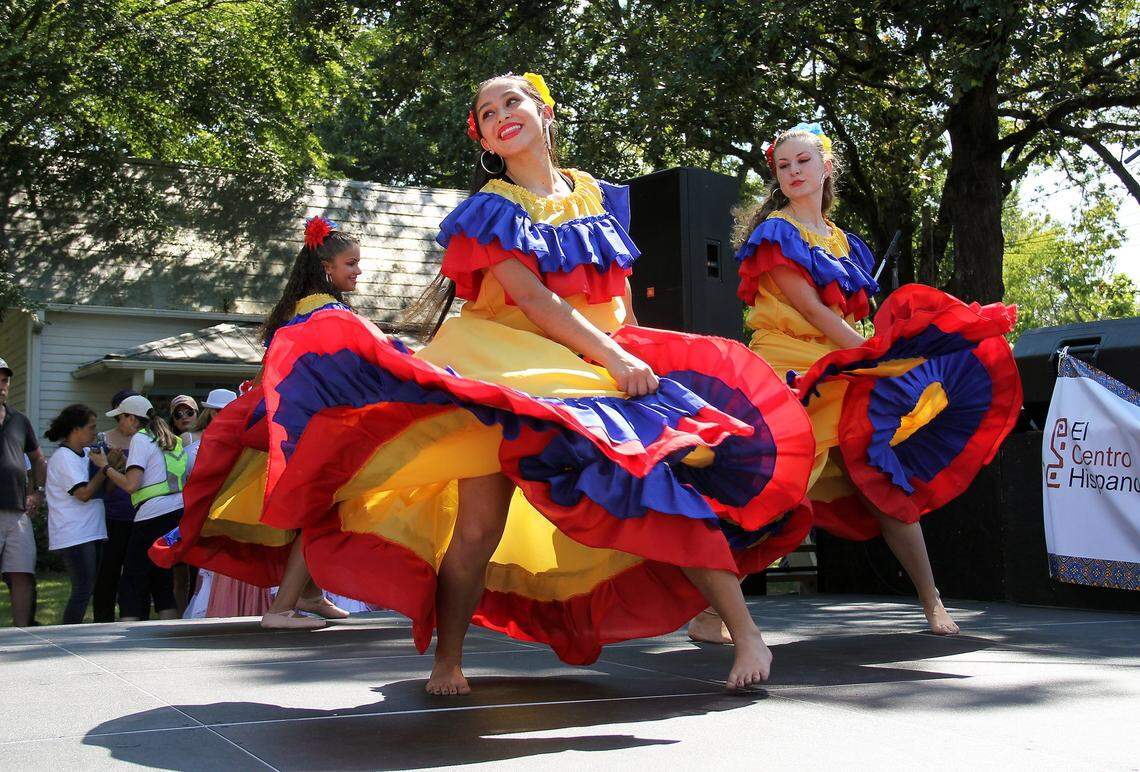 From left, Rosa Ramirez, 17, Mariana Rocha Goldberg, 16, an Annie Witte, 16, perform folk dances from Colombia on Saturday, Aug. 28, 2016. Hundreds attended the third annual Latin American Festival held by El Centro Hispano outside the agency’s West Weaver Street office in Carrboro.