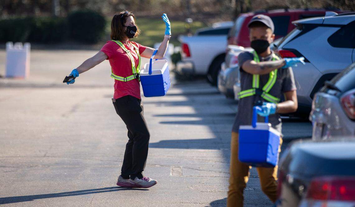 Staff at the Wake County COVID-19 testing site on Departure Drive collects test samples in their coolers and direct traffic in and out of the location on Tuesday, December 28, 2021 in Raleigh, N.C. The rapid spread of the omicron variant combined with the Christmas Holiday, has increased the demand for testing.
