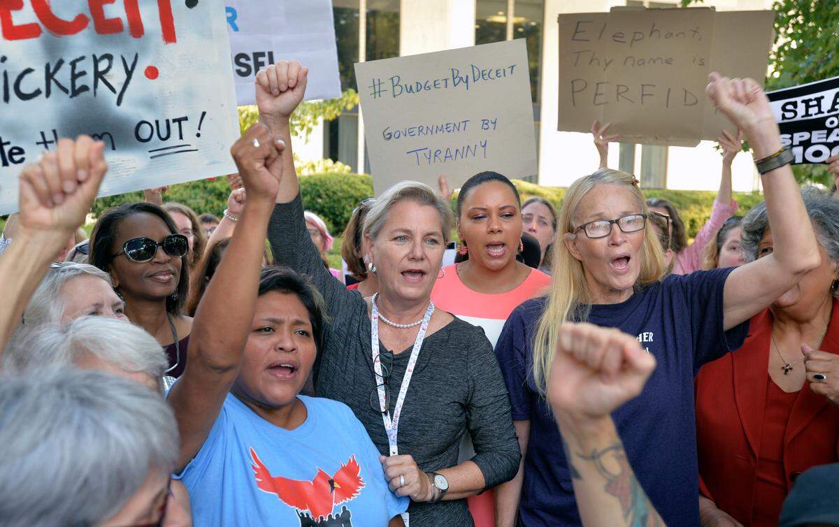 Supporters surround Rep. Deb Butler and chant “Refuse to Yield” at a rally protesting the surprise vote by the House Wednesday overriding the Governor’s veto of the budget.  Butler, who spoke out loudly in opposition during the session and refused to yield the floor, attended a rally outside of the Legislature in Raleigh, N.C. Thursday morning Sept. 12, 2019.