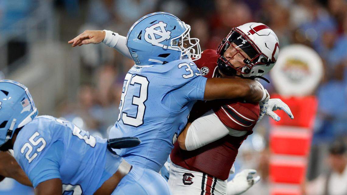 South Carolina quarterback Spencer Rattler (7) passes just as he is hit by North Carolina linebacker Cedric Gray (33) during the first half of UNC’s game against South Carolina in the Duke’s Mayo Classic at Bank of America Stadium in Charlotte, N.C., Saturday, Sept. 2, 2023.