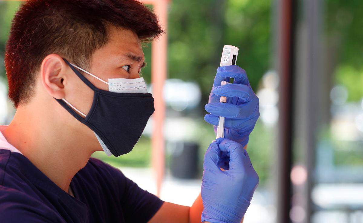 Jae Jung with inClinic RX prepares a Moderna COVID-19 vaccine shot during a free vaccine clinic in Moore Square in downtown Raleigh, N.C. Tuesday, May 4, 2021. The clinic, sponsored by Eastern Carolina Medical Center, inClinic RX, Avance Care and Empire Eats, will be open from noon to 5 Wednesday through Friday.