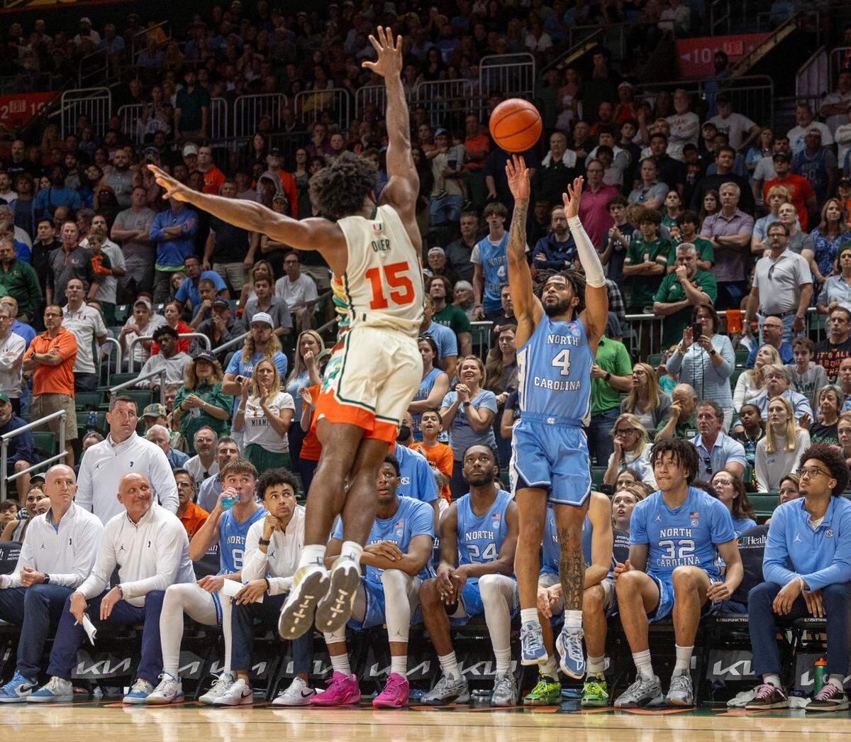 North Carolina’s R.J. Davis (4) launches a three-point shot over Miami’s Norchad Omier (15) in the second half on Saturday, February 10, 2024 at the Watsco Center in Coral Gables, Florida. Davis led all scores with 25 points in the Tar Heels’ 75-72 victory.