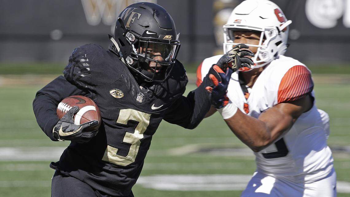 Wake Forest’s Greg Dortch (3) runs as Syracuse’s Antwan Cordy (8) defends in the first half of an NCAA college football game in Charlotte, N.C., Saturday, Nov. 3, 2018. (AP Photo/Chuck Burton)