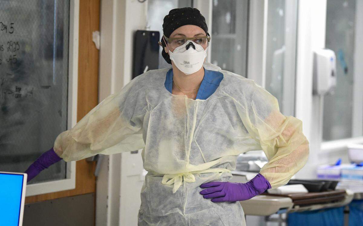 Registered nurse Katie Creran prepares to enter a COVID patient’s room in the surgical/trauma ICU at UNC Hospital in Chapel Hill, N.C., Thursday, January 27, 2022.