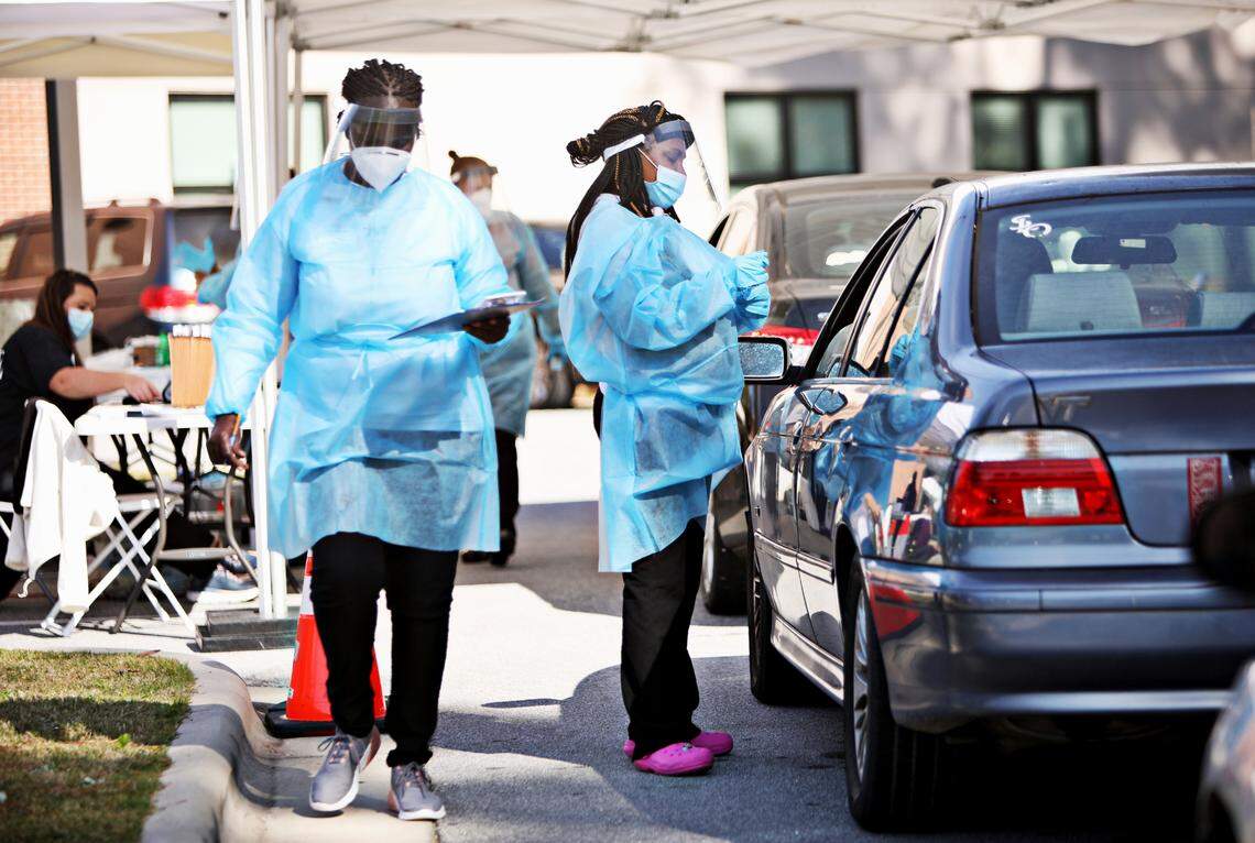 Jaylia Allen, MA, right, collects a sample from a client at a COVID-19 testing drive-thru for Advance Community Health in Raleigh on Thursday, Nov. 5, 2020. Advance Community Health hosts several free testing sites each week.