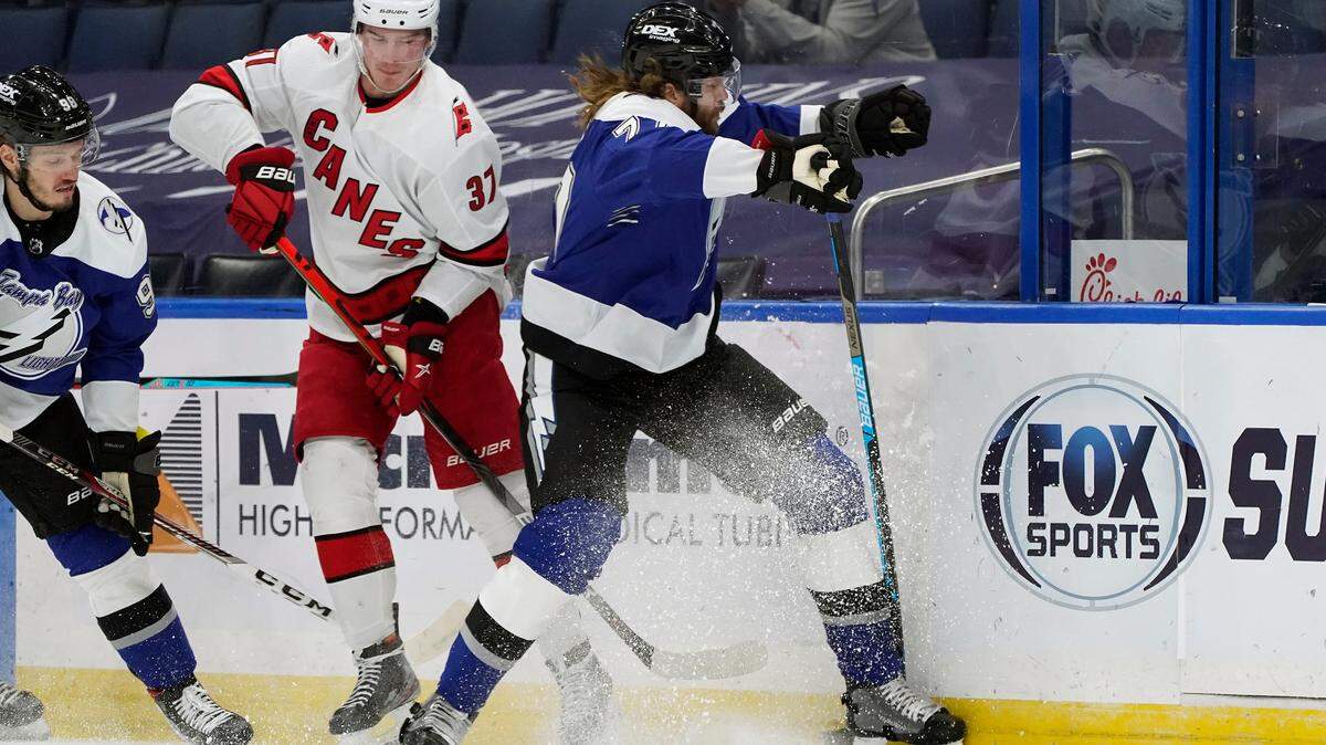 Tampa Bay Lightning defenseman Victor Hedman (77) misses a check on Carolina Hurricanes right wing Andrei Svechnikov (37) during the first period of an NHL hockey game Thursday, Feb. 25, 2021, in Tampa, Fla. (AP Photo/Chris O’Meara)