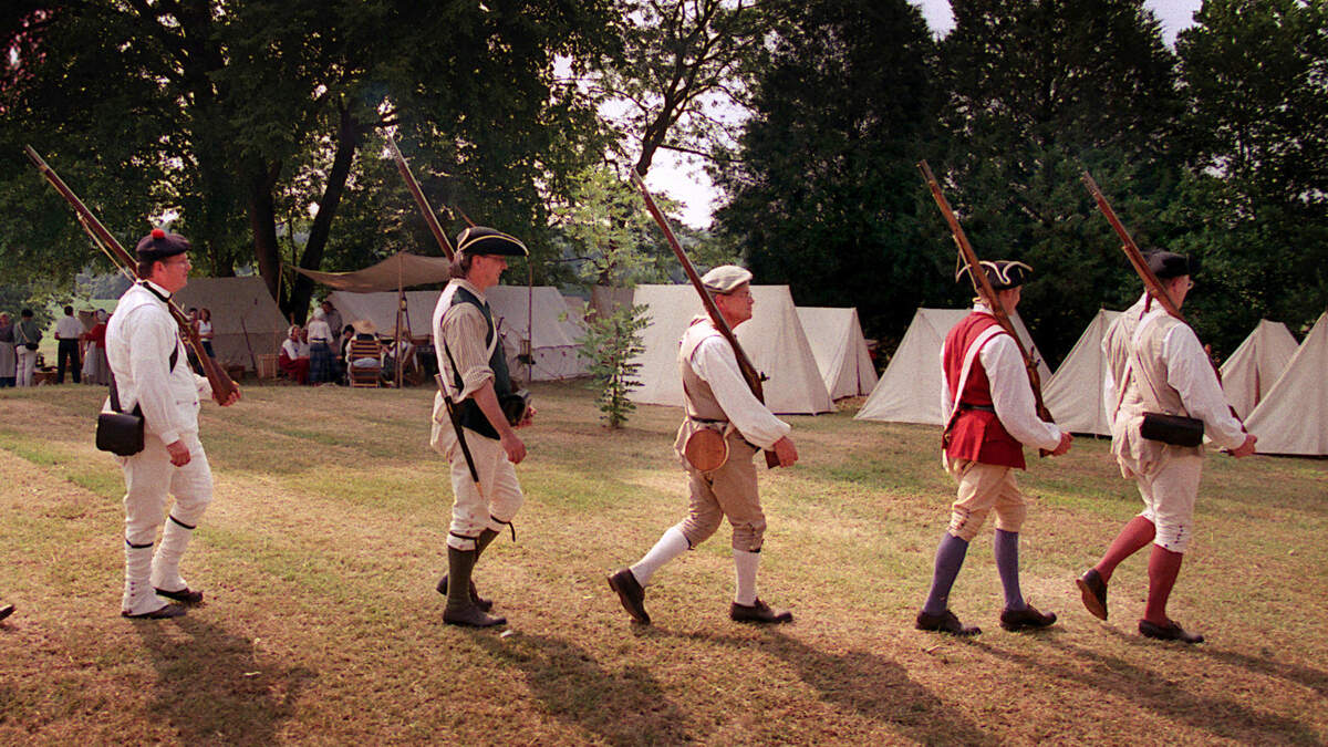 American Revolution re-enactors from the N.C. Highland Regiment march back to their campsite after "fighting" in a skirmish as the House in the Horseshoe in northern Moore County.