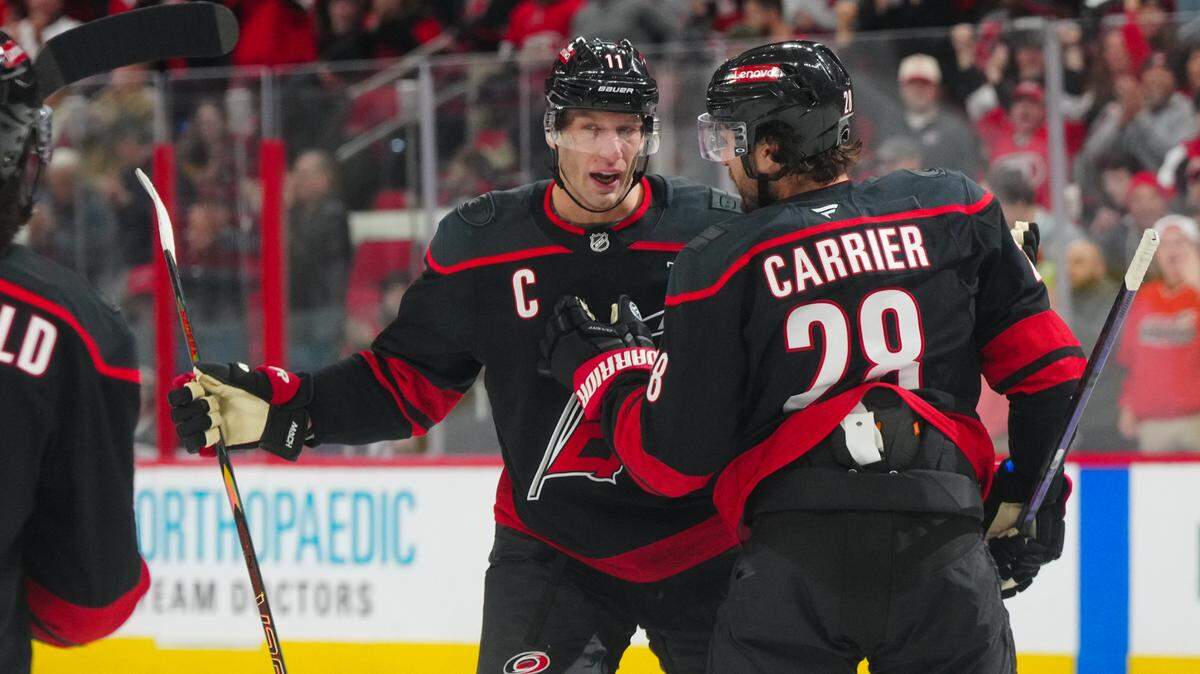 Dec 15, 2024; Raleigh, North Carolina, USA;  Carolina Hurricanes left wing William Carrier (28) celebrates a goal with center Jordan Staal (11) against the Columbus Blue Jackets during the first period at Lenovo Center. James Guillory-Imagn Images