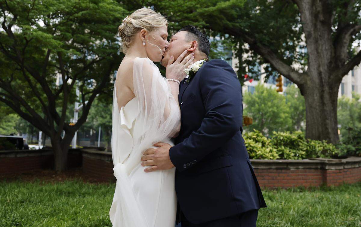 Rebecca Stewart and Billy Khantawong kiss after they were married in Nash Square Park in Raleigh, N.C., Friday, May 22, 2026.