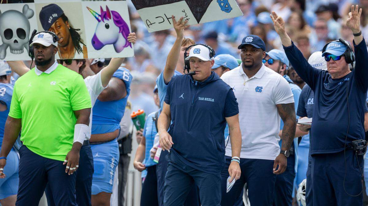 North Carolina defensive coordinator Geoff Collins, center, and head coach Mack Brown, signal to their players in the second quarter against James Madison on Saturday, September 21, 2024 at Kenan Stadium in Chapel Hill, N.C.