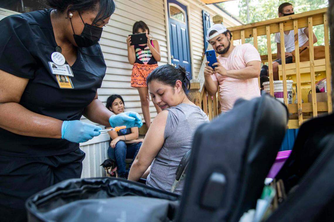 Dr. Nerissa Price administers a COVID-19 vaccine to Yeni Umanzor, 21, as volunteer canvassers went door to door offering vaccines at a Raleigh mobile home park in Raleigh Friday, July 23, 2021. Using Census tract data to identify low vaccination areas in Wake County, outreach teams are working to increase vaccine rates in communities with low vaccination rates.