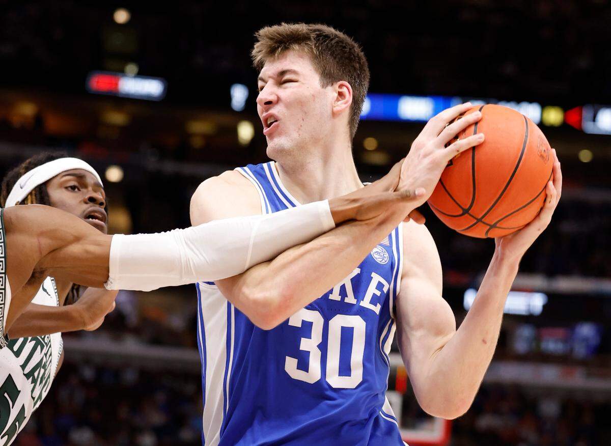 Michigan State’s Tyson Walker (2) and Coen Carr (55) try to slow down Duke’s Kyle Filipowski (30) during the second half of Duke’s 74-65 victory over Michigan State in the Champions Classic at the United Center in Chicago, IL, Tuesday, Nov. 14, 2023.
