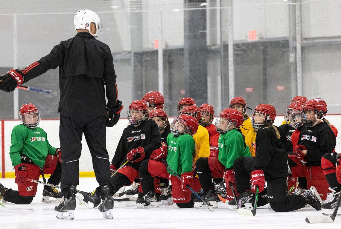 Junior Canes girls hockey players listen to instructions during a practice at Invisalign Arena in Morrisville, N.C. on Tuesday, Sept. 19, 2023. 