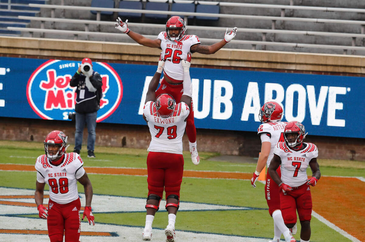 N.C. State offensive lineman Ikem Ekwonu (79) celebrates with Trent Pennix (26) after Pennix’s five-yard touchdown reception during the first half of N.C. State’s game against Virginia at Scott Stadium in Charlottesville, Va., Saturday, Oct. 10, 2020.