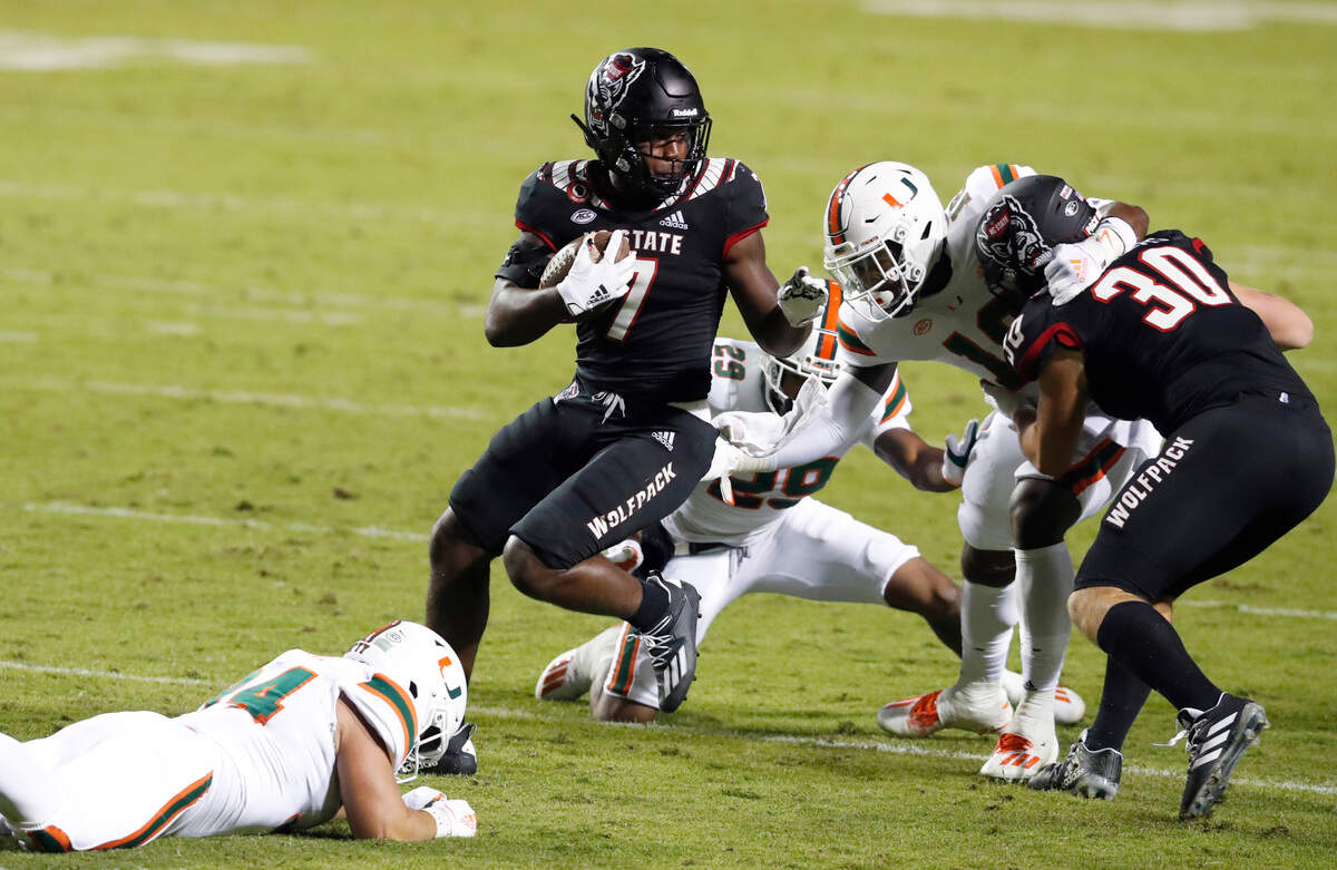N.C. State running back Zonovan ‘Bam’ Knight (7) spins around Miami defenders during his 100-yard kickoff return for a touchdown in the second half of Miami’s 44-41 victory over N.C. State at Carter-Finley Stadium in Raleigh, N.C., Friday, Nov. 6, 2020.
