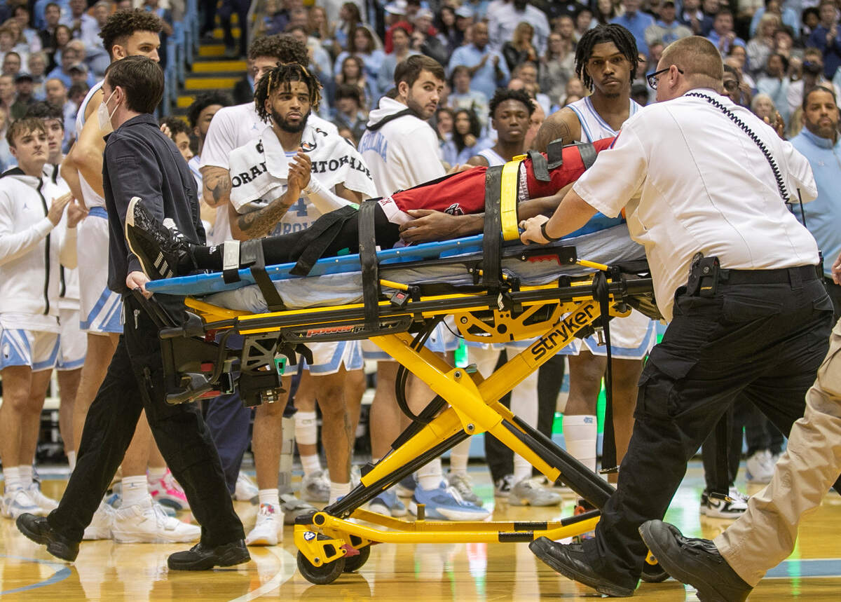 North Carolina players R.J. Davis (4) and Caleb Love (2) watch as N.C. State’s Terquavion Smith (0) is taken from the court by medical personnel, after falling on a hard foul by North Carolina’s Leaky Black in the second half. Smith was taken to the hospital and Black was ejected from the game on Saturday, January 21, 2023 at the Smith Center in Chapel Hill, N.C.