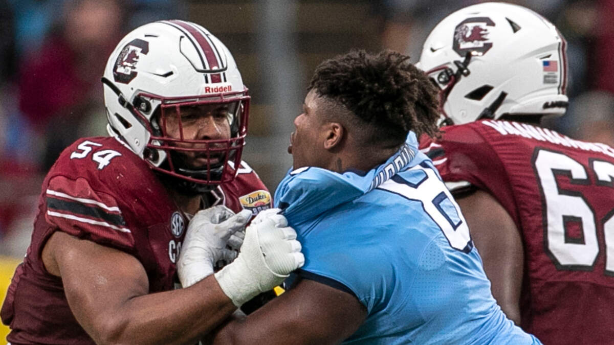 North Carolina defensive lineman Myles Murphy (8) tangles with South Carolina’s Jovaughn Gwyn (54) after losing his helmet the Gamecocks’ 38-21 victory during the Duke’s Mayo Bowl at Bank of America Stadium in December 2021.