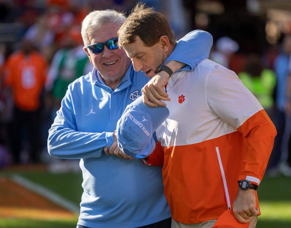 North Carolina coach Mack Brown embraces Clemson coach Dabo Swinney prior to a game in 2023. Clemson and Florida State are both threatening to leave the ACC, and Brown said he has no idea whether UNC one day will as well.