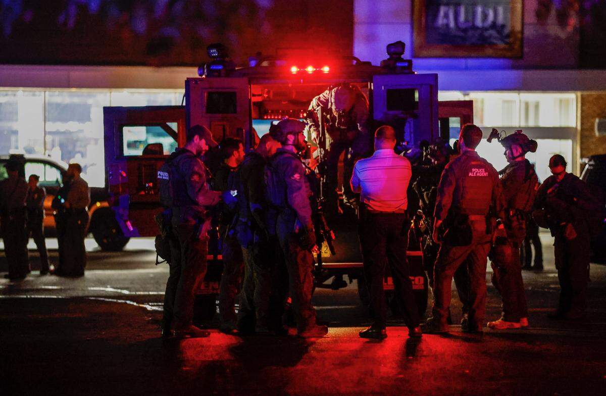 Law enforcement officers congregate outside an armored vehicle at the Aldi on New Bern Avenue in Raleigh after 5 people were shot and killed in the Hedingham Neighborhood and Nuese River Trail area in Raleigh Thursday, Oct. 13, 2022.