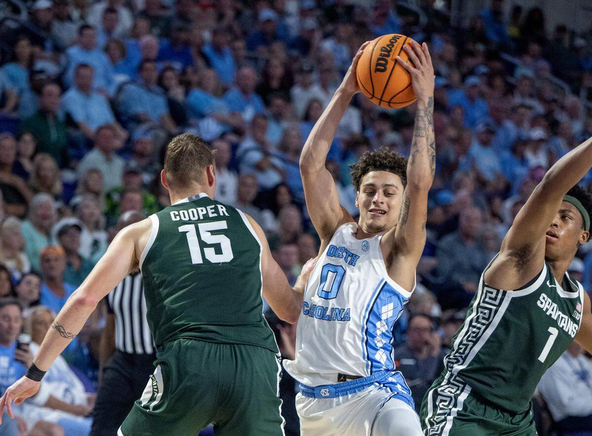 UNC’s Kyan Evans (0) grabs the ball against Michigan State’s Carson Cooper (15) and Jeremy Fears Jr. (1).