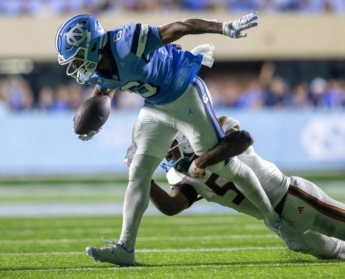 North Carolina’s Nate McCollum (6) picks up 15-yards on a pass completion from quarterback Drake Maye before being stopped by Miami’s Kamren Kinchens (5) in the fourth quarter against Miami on Saturday, October 14, 2023 at Kenan Stadium in Chapel Hill, N.C.