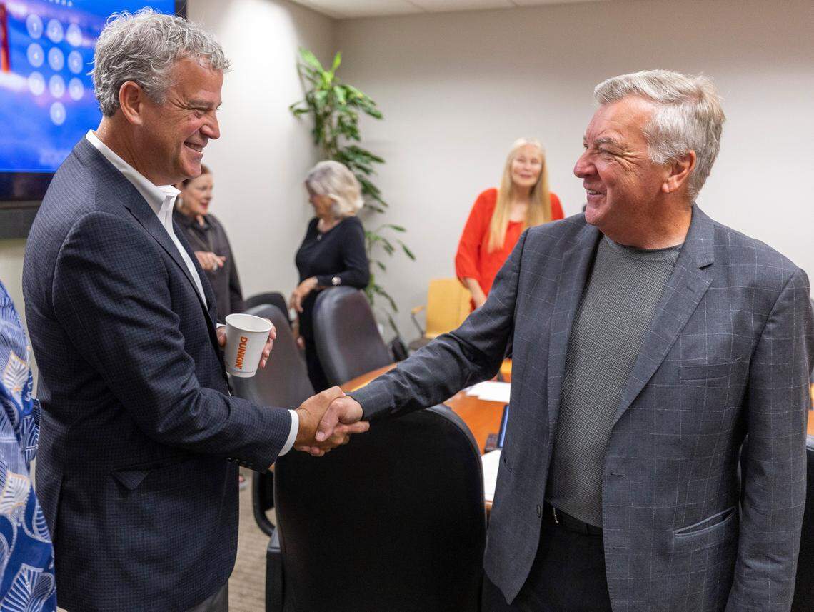 North Carolina State Athletic Director Boo Corrigan shakes hands with Carolina Hurricanes General Manager Don Waddell following a meeting of the Centennial Authority where they voted unanimously to approve a 20-year lease extension for the Hurricanes on Tuesday, August 15, 2023 at PNC Arena in Raleigh, N.C. The agreement will also move ahead with investment in mixed-use development around the area that would include housing, a hotel and a music venue.