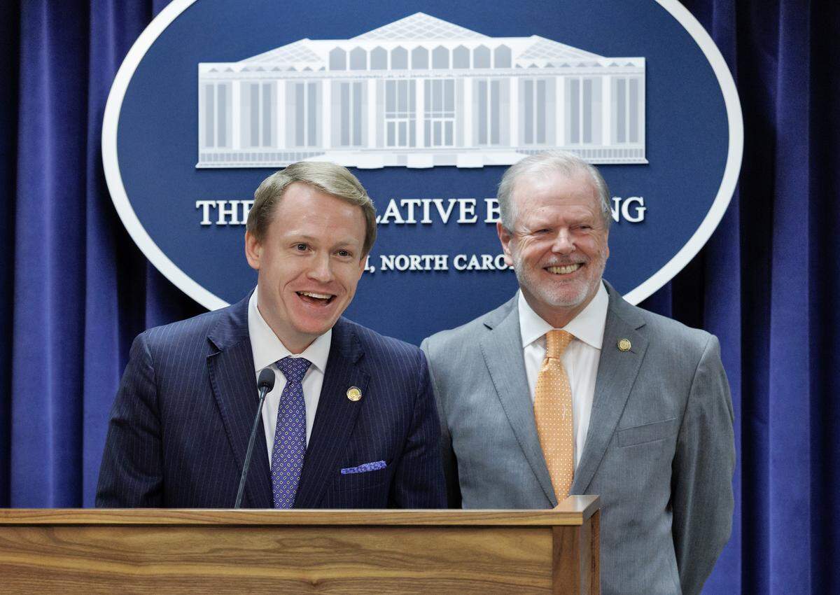 House Speaker Destin Hall and Senate leader Phil Berger smile while taking questions from reporters during a press conference to announce a state budget deal at the Legislative Building on Tuesday, May 12, 2026, in Raleigh, N.C.
