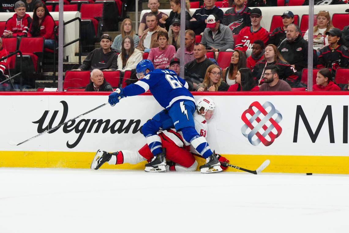 Tampa Bay Lightning defenseman Steven Santini (64) checks Carolina Hurricanes right wing Jackson Blake (53) during the first period at PNC Arena on Oct. 4, 2024.