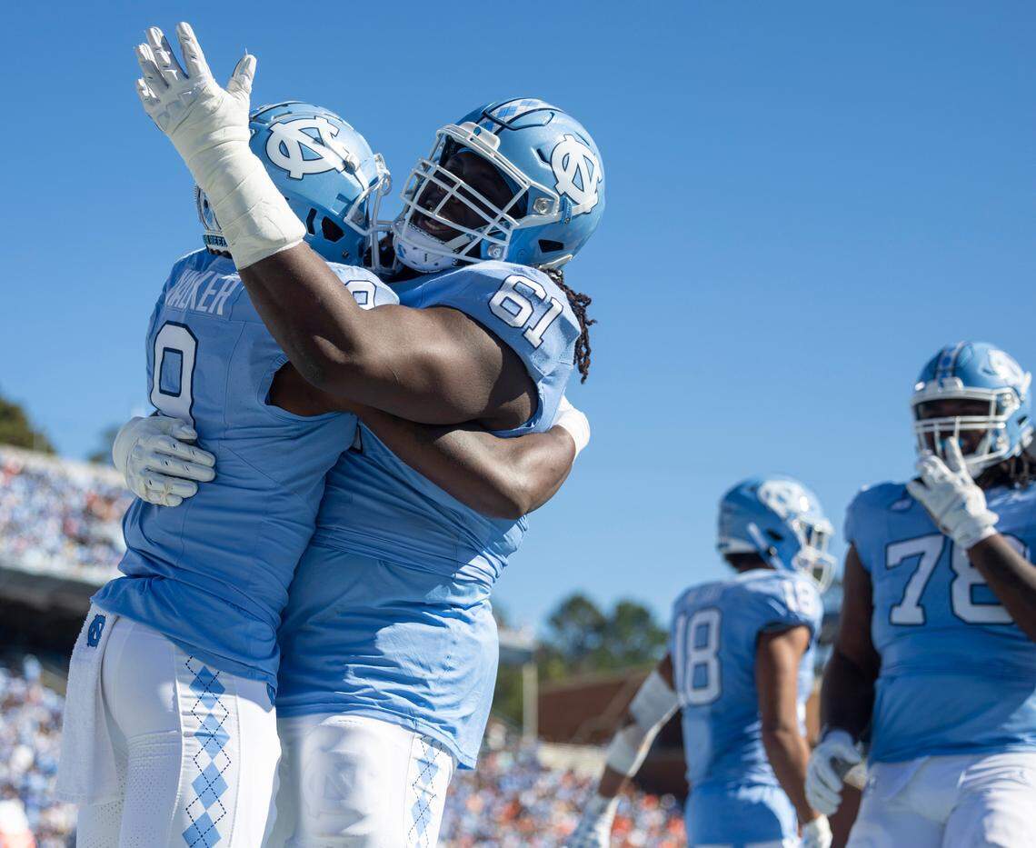 North Carolina’s Diego Pounds (61) embraces Devontez Walker (9) after his 31-yards pass reception from quarterback Drake Maye in the second quarter on Saturday, November 4. 2023 at Kenan Stadium in Chapel Hill, N.C.