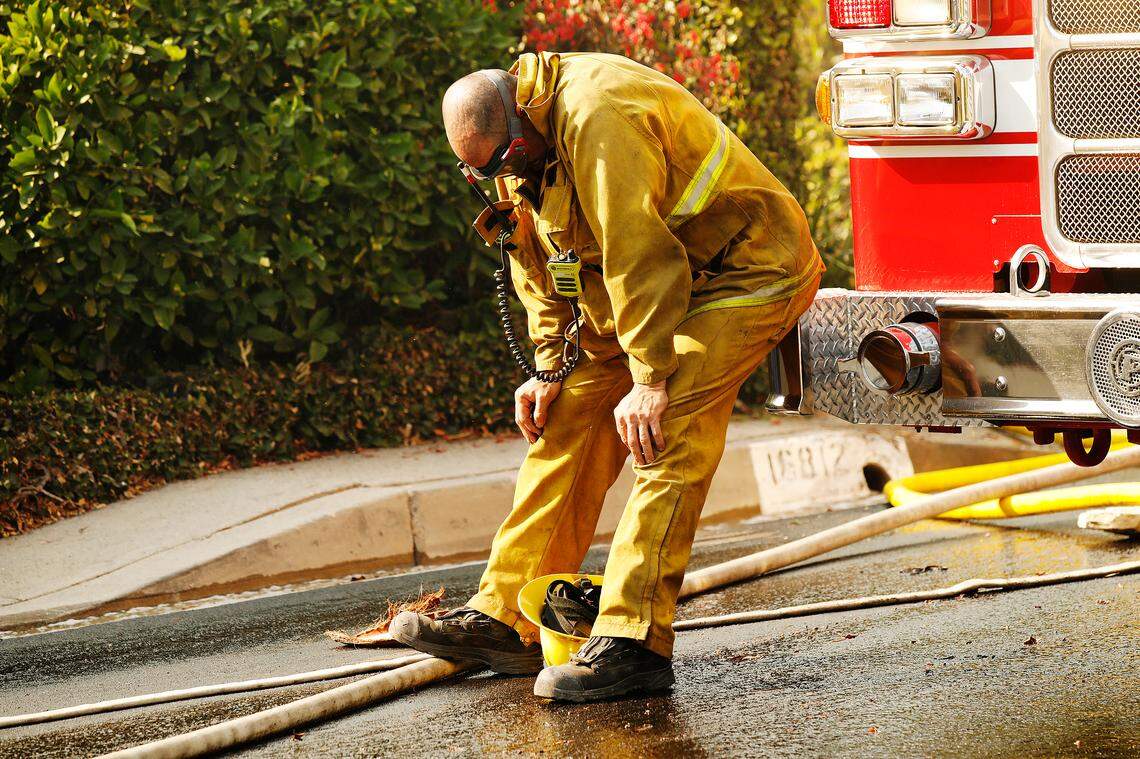 Los Angeles City Firefighter Jeffrey Escalante catches his breath as Los Angeles fire crews respond to a brush fire near Palisades Drive in Pacific Palisades on Oct. 21, 2019 in Los Angeles.
