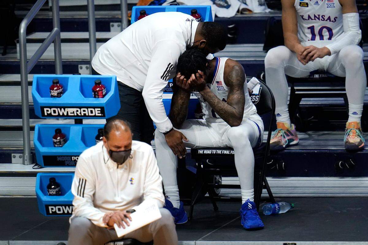 Kansas guard Marcus Garrett (0) is comforted by staff during the second half of a men’s college basketball game in the second round of the NCAA tournament at Hinkle Fieldhouse in Indianapolis, Monday, March 22, 2021. USC won 85-51. 