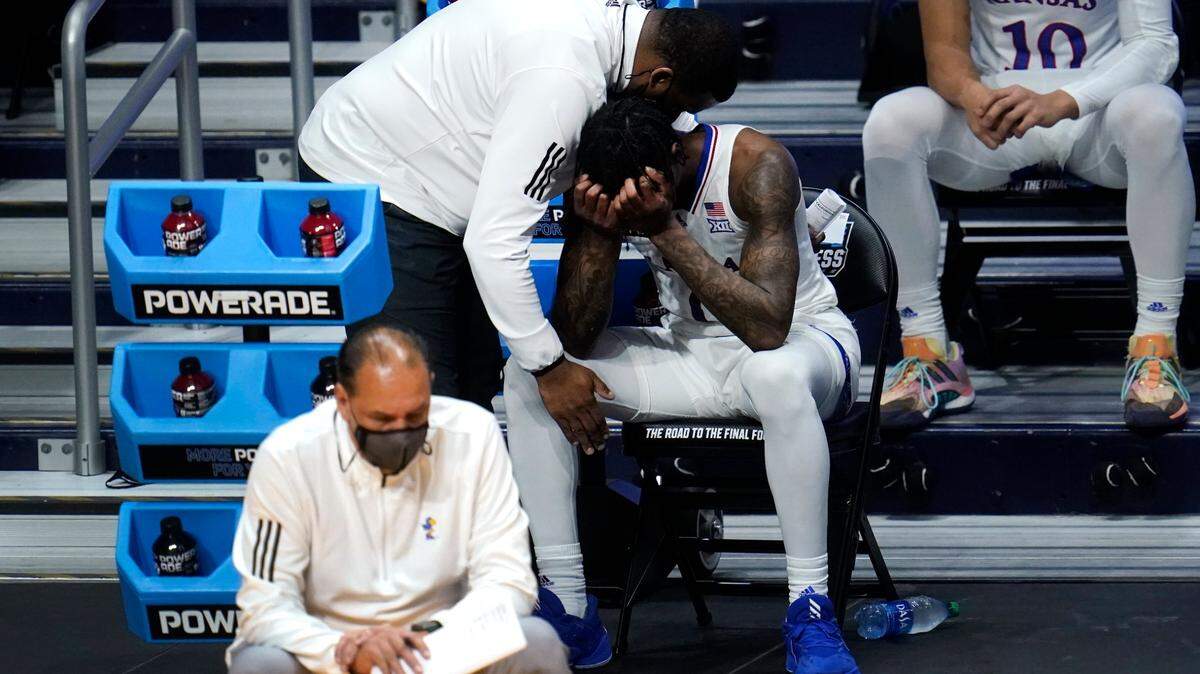 Kansas guard Marcus Garrett (0) is comforted by staff during the second half of a men’s college basketball game in the second round of the NCAA tournament at Hinkle Fieldhouse in Indianapolis, Monday, March 22, 2021. USC won 85-51.