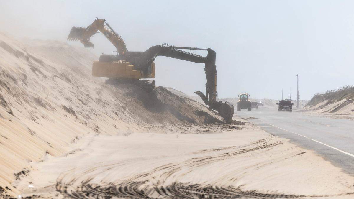 NC DOT crews clear sand along highway NC 12&nbsp;on Pea Island Thursday, Sept. 14, 2023 as Hurricane Lee churns on a Northward track hundreds of miles offshore in the Atlantic. 