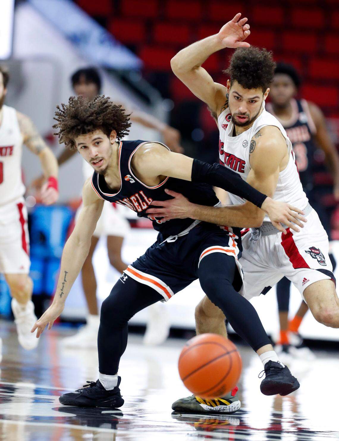 Campbell’s Jordan Whitfield (11) and N.C. State’s Devon Daniels (24) go after the loose ball during the first half of N.C. State’s game against Campbell at PNC Arena in Raleigh, N.C., Saturday, Dec. 19, 2020.
