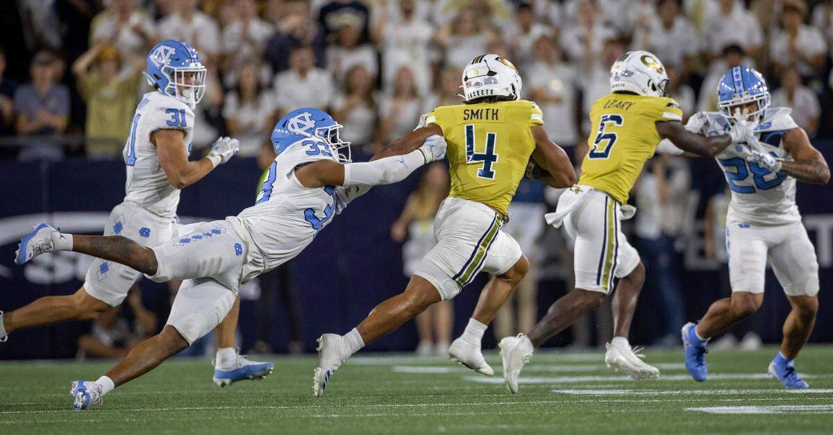 North Carolina’s Cedric Grey (33) makes a diving attempt to stop Georgia Tech’s Donte Smith (4) as he rushes for 11 yards and a first down on Saturday, October 28, 2023 at Bobby Dodd Stadium in Atlanta, Georgia. Smith rushed for 178 yards and one touchdown in the Yellow Jackets’ 46-42 victory.