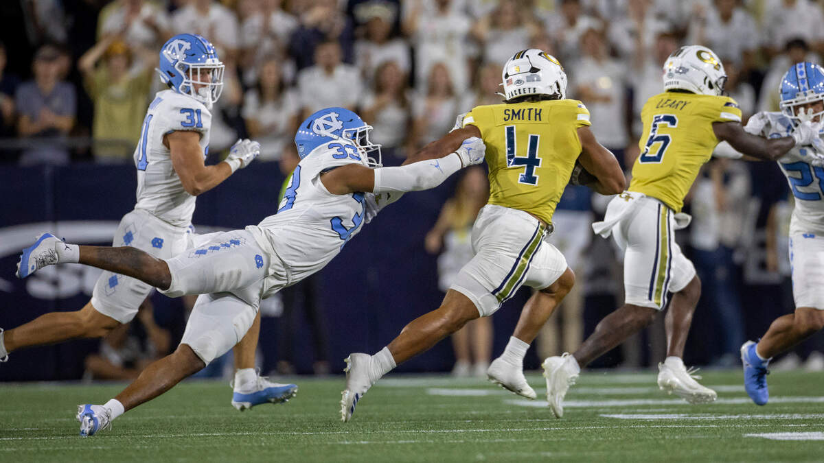 North Carolina’s Cedric Grey (33) makes a diving attempt to stop Georgia Tech’s Donte Smith (4) as he rushes for 11 yards and a first down on Saturday, October 28, 2023 at Bobby Dodd Stadium in Atlanta, Georgia. Smith rushed for 178 yards and one touchdown in the Yellow Jackets’ 46-42 victory.