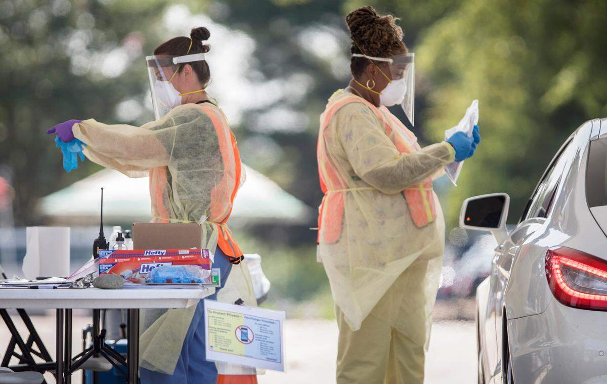 Nurses with Wake County Health and Human Services prepare to administer COVID-19 tests at a drive-thru testing site in the McKimmon Center parking lot in Raleigh, N.C. on Monday, July 6, 2020.