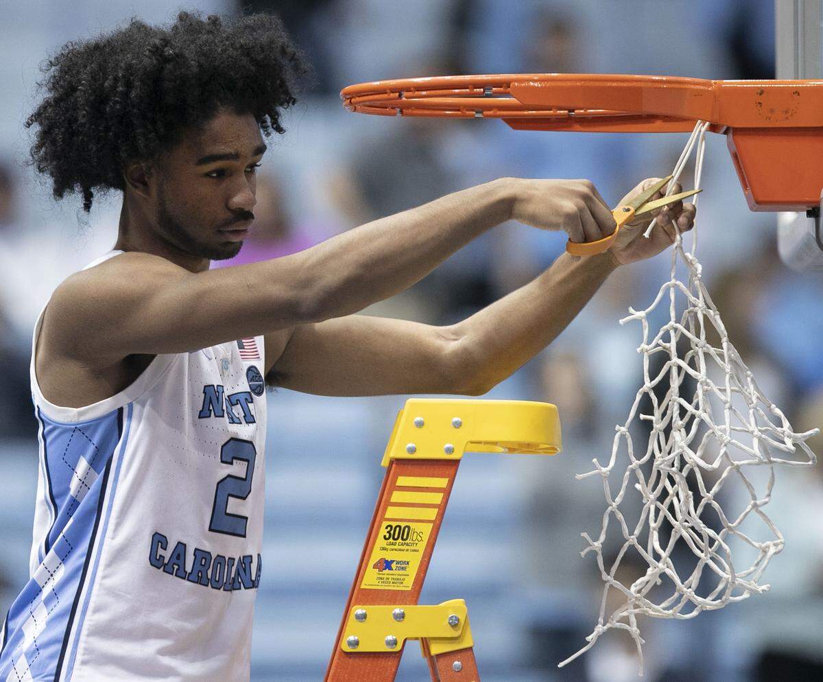 North Carolina’s Coby White (2) cuts down the net after the Tar Heels clinched a share of the ACC regular-season championship with a win over Duke on Saturday, March 9, 2019 at the Smith Center in Chapel Hill, N.C.
