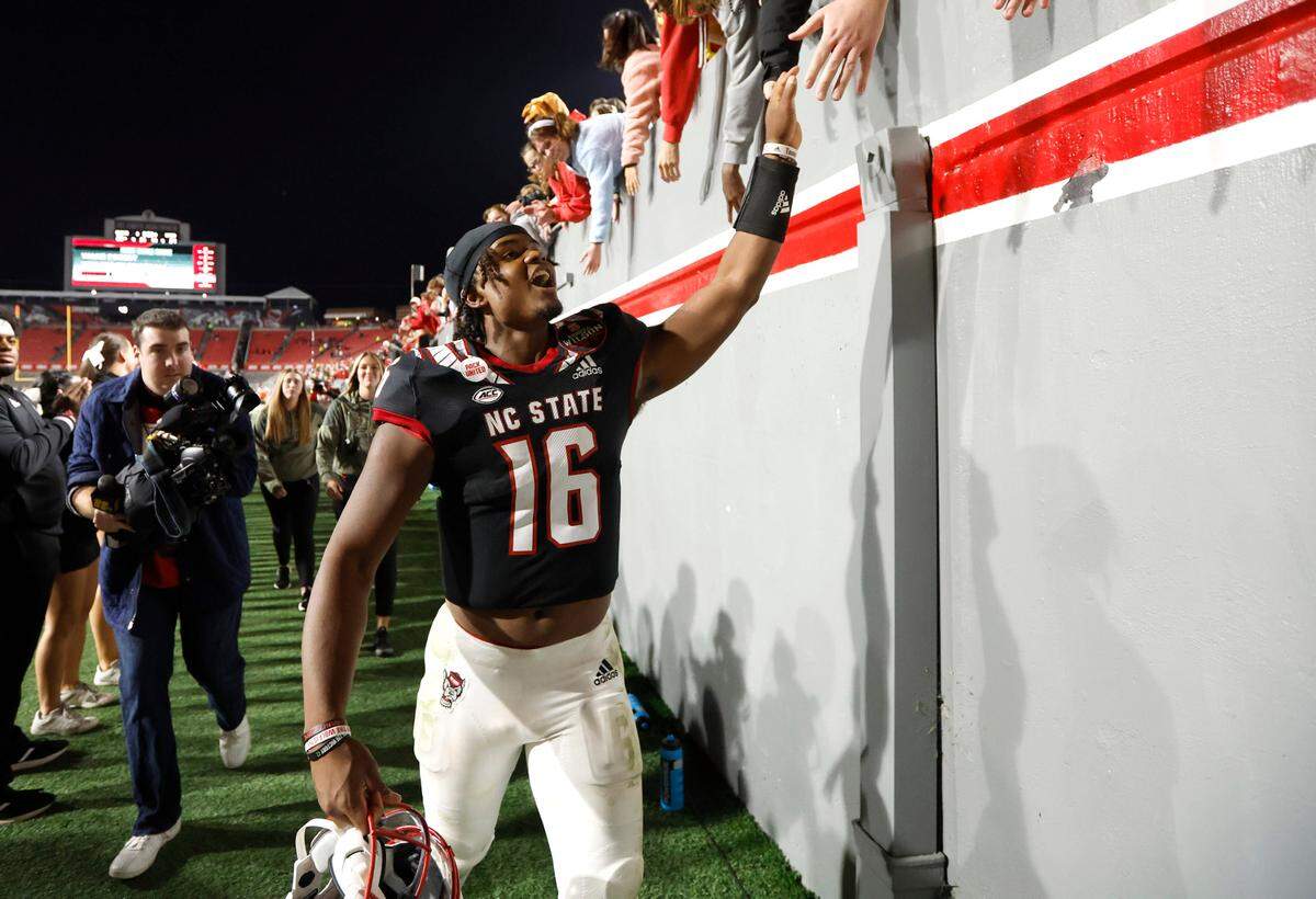 N.C. State quarterback MJ Morris (16) celebrates with fans after N.C. State’s 22-21 victory over Virginia Tech at Carter-Finley Stadium in Raleigh, N.C., Thursday, Oct. 27, 2022.