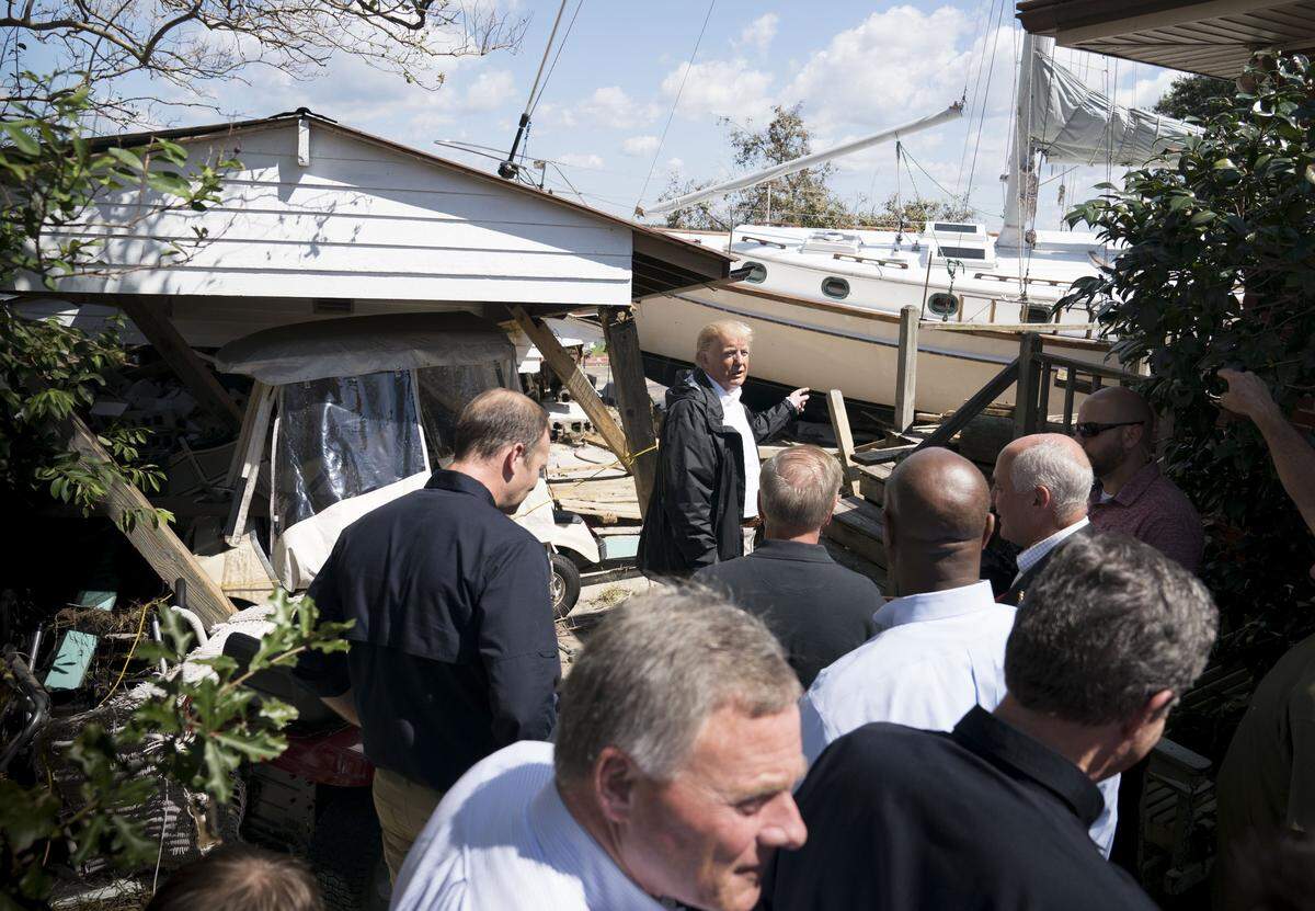 President Donald Trump looks at a sailboat in a yard while surveying Hurricane Florence damage in New Bern, N.C., Sept. 19, 2018.