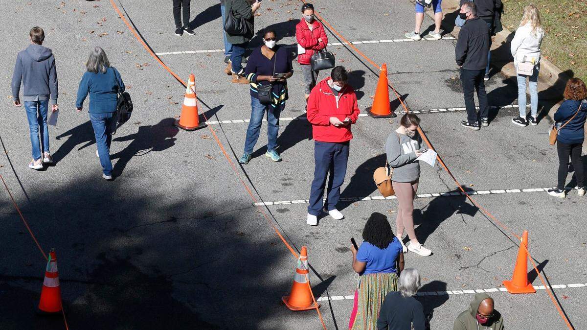Voters wait in line to to cast their ballots at the Herbert C. Young Community Center on Saturday, October 17, 2020 in Cary, N.C.